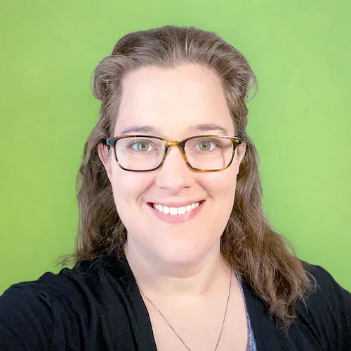 Photo of a woman with glasses against a lime green background.